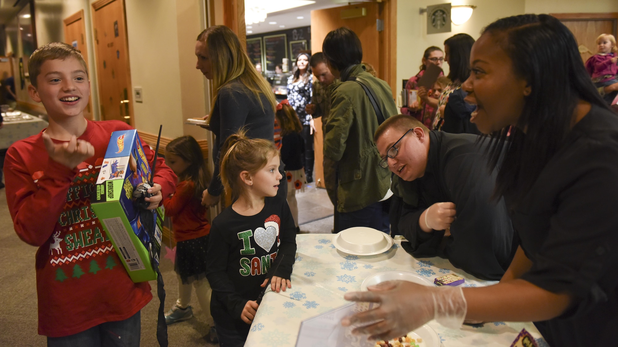 A young Team Whiteman member, outer left, tries a booger-flavored jelly bean during the annual tree lighting event
at Whiteman Air Force Base, Mo., Nov. 29, 2016. In addition to the candy, volunteers set up different wizard-themed
activities to help make the night magical.
