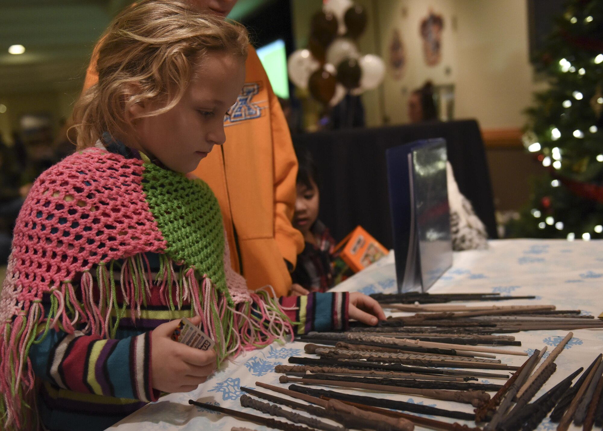 A young Team Whiteman member chooses a handmade wand during the annual tree lighting event at Whiteman Air Force Base, Mo., Nov. 29, 2016. More than 300 wands were made by volunteers to help make the wizard-themed event special.