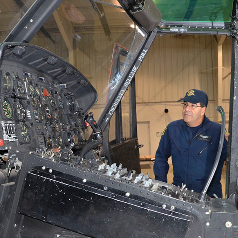 Sergeant Jerry King, a pilot with the Michigan State Police Aviation unit, looks over the controls of the UH-1 “Huey” Iroquois helicopter that came from the Army via the DLA Disposition Services Law Enforcement Support Office. 