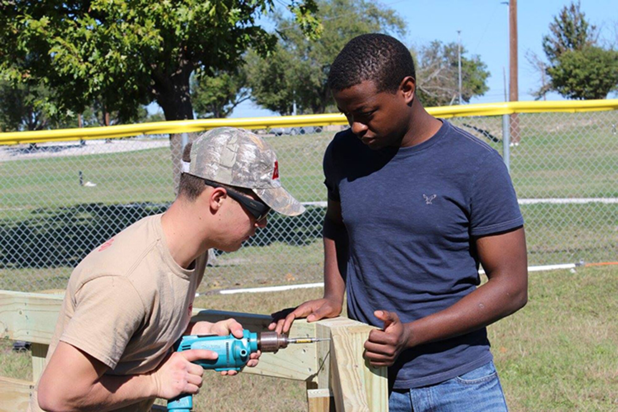 Brandan Paradis, Boy Scouts Troop 280, drills a screw into a gaga ball pit
with the help of Airman 1st Class Teddy Mukeli, 47th Civil Engineering
Squadron, on Laughlin Air Force Base Nov.19. The gaga ball pit, built for
the Laughlin Air Force Base Youth Center as an Eagle Scout project, allows
children here to play a game similar to dodge ball. (Courtesy photo by Sunshine Burgess)
