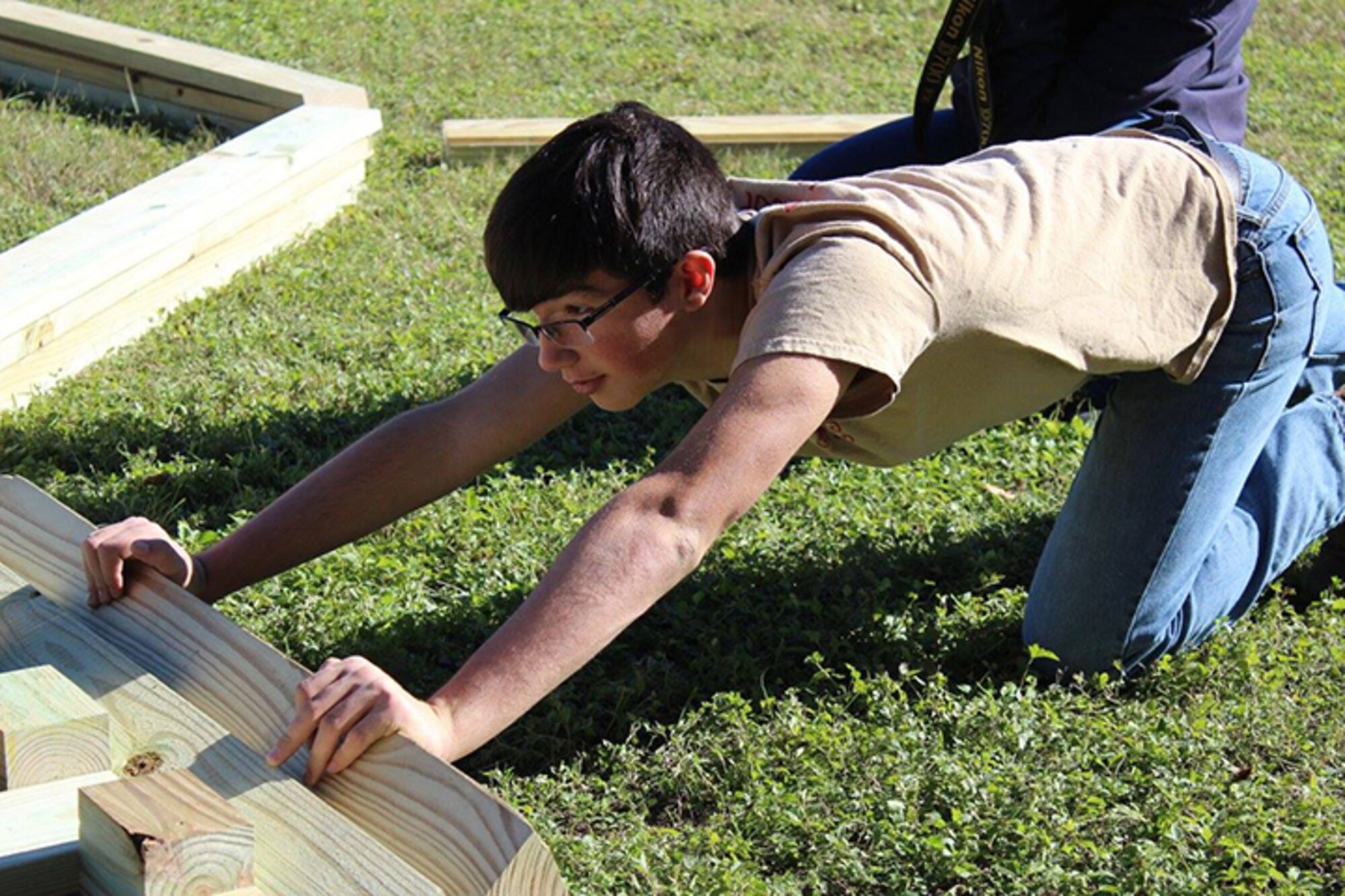 Dalton Burgess, Boy Scouts Troop 280, holds a piece wood in place during the
construction of a gaga ball pit on Laughlin Air Force Base Nov.19. The gaga
ball pit, built for the Laughlin Air Force Base Youth Center as Burgess'
Eagle Scout project, allows children here to play a game similar to dodge
ball. (Courtesy photo by Sunshine Burgess)
