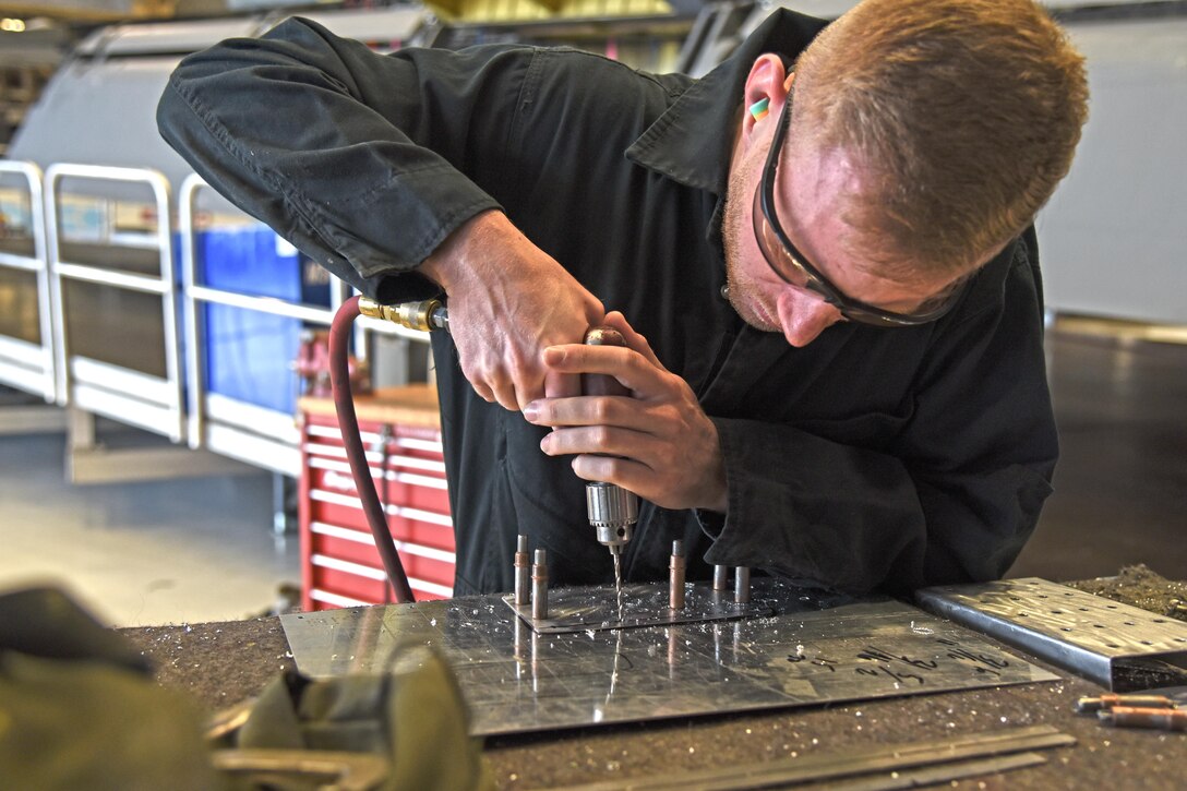 Senior Airman Logan Lingren, 92nd Maintenance Squadron aircraft structural maintenance technician, creates a rivet pattern on a piece of sheet metal Nov. 15, 2016, at Fairchild Air Force Base. Lingren has been at Fairchild since 2012. He leads many programs in his shop and trains new Airmen on the basics of aircraft structural maintenance. (U.S. Air Force photo/Senior Airman Mackenzie Richardson)