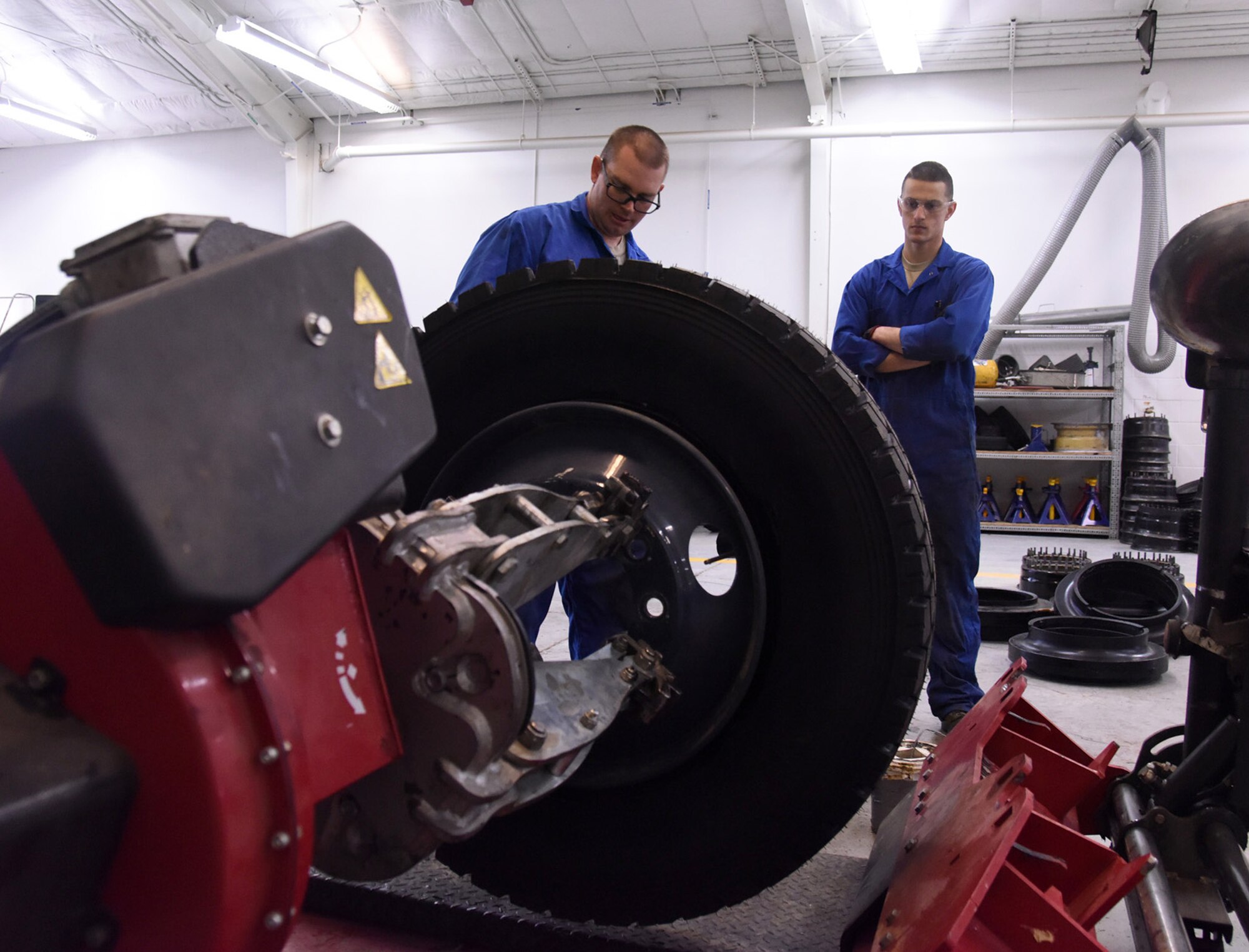 Staff Sgt. Benjamin Fisher, 341st Logistics Readiness Squadron vehicle maintenance journeyman, left, and Airman 1st Class Johnathan Allen, 341st Logistics Readiness Squadron vehicle maintenance apprentice, air up a semi-truck tire with a tire machine at the LRS tire shop Dec. 1, 2016, at Malmstrom Air Force Base, Mont. The tire machine is used to make it easier to conduct work on the tire by adding air or using a sealant. (U.S. Air Force photo/Senior Airman Jaeda Tookes)

