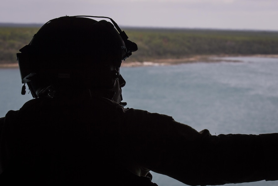 A flight engineer with the 8th Special Operations Squadron looks out at the Eglin Range, Fla., Nov. 30, 2016. Air Commandos with the 8th SOS conduct water training to maintain relevance for tomorrow and ensure readiness for global special operations. (U.S. Air Force photo by Airman 1st Class Joseph Pick)