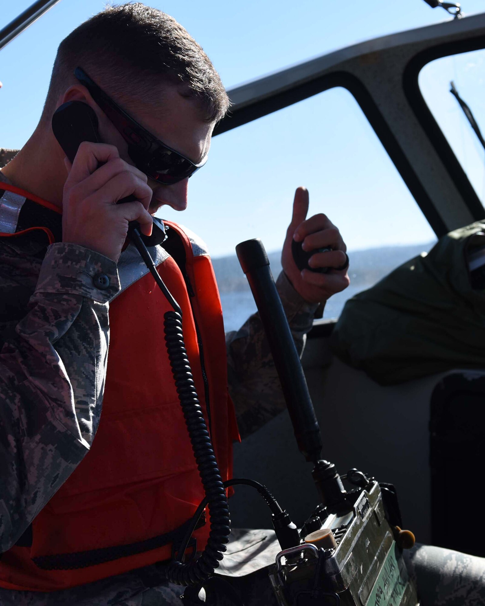 U.S. Air Force Senior Airman Aaron Elmore, 19th Operation Support Squadron air traffic control journeyman, gives aircrews clearance to drop their supplies during a search and rescue exercise as part of a Turkey Shoot competition Nov. 17, 2016, at Lake Ouachita, Ark. This was the first search and rescue exercise performed at Lake Ouachita by Little Rock AFB. (U.S. Air Force photo by Airman 1st Class Kevin Sommer Giron)