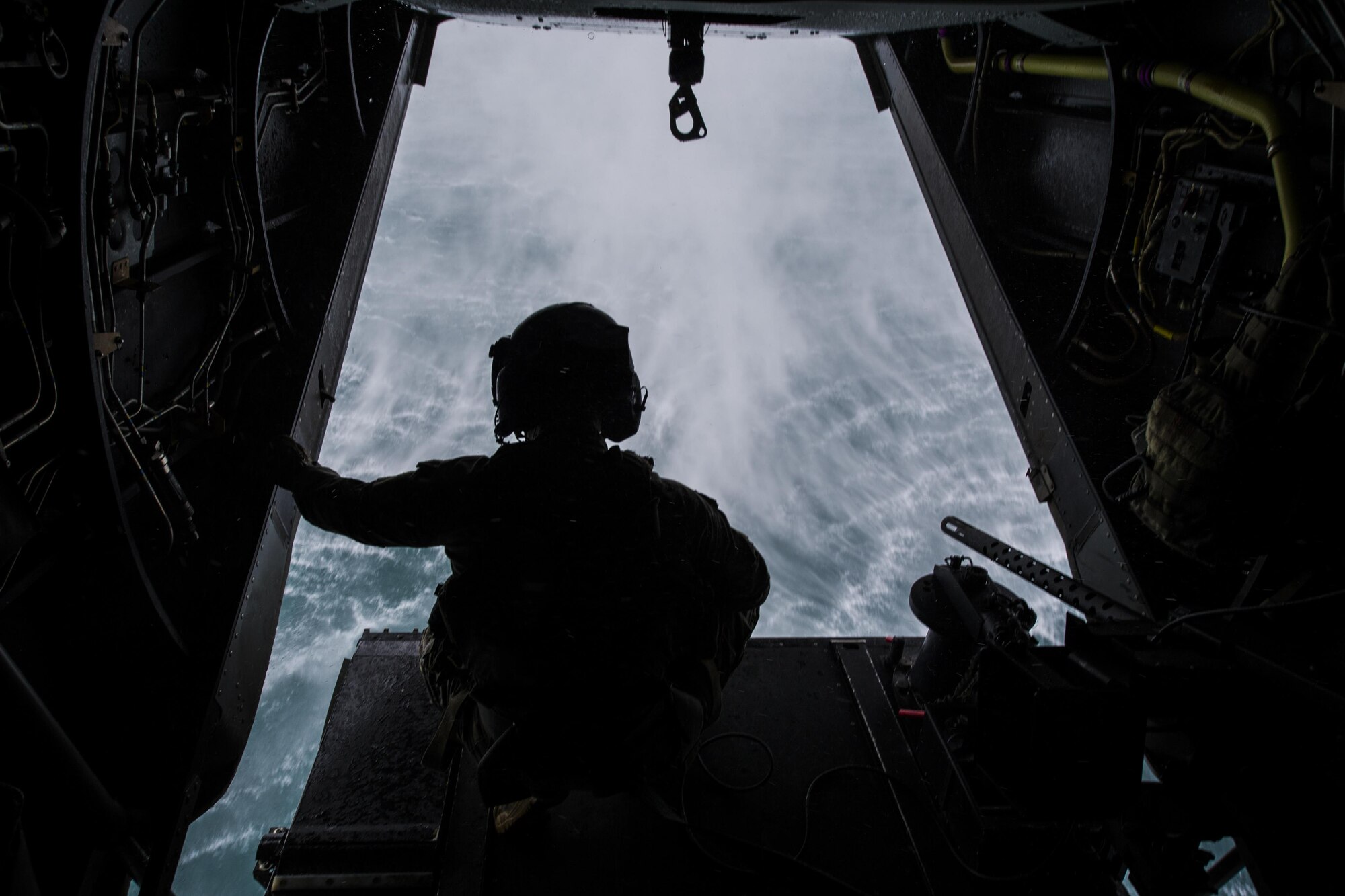 A flight engineer with the 8th Special Operations Squadron watches as he hovers over a pond in a CV-22 Osprey tiltrotor aircraft during water training at Eglin Range, Fla., Nov. 30, 2016. Air Commandos with the 8th SOS conduct water training as a way to maintain relevance for tomorrow and ensure readiness for global special operations. (U.S. Air Force photo by Airman 1st Class Joseph Pick)