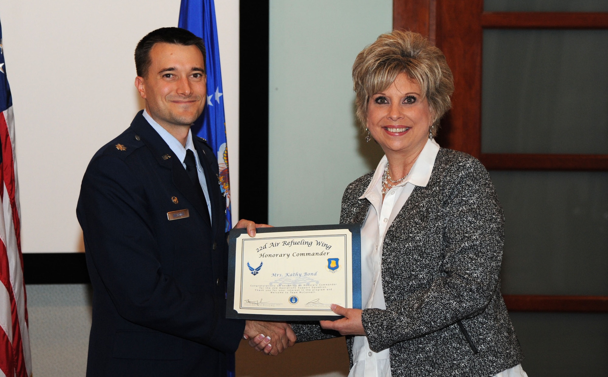 Lt. Col. Aaron Walenga, left, 22nd Operations Support Squadron commander, presents a certificate to Kathy Bond, 22nd OSS honorary commander, Nov. 30, at McConnell Air Force Base, Kan. The honorary commander program spreads awareness of McConnell’s mission and build connections between the base and the community. (U.S. Air Force photo/Airman 1st Class Jenna Caldwell)