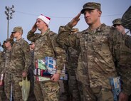 A formation of Army explosive ordnance disposal students salute during base retreat at Eglin Air Force Base, Fla, Dec. 1.  A few of the soldiers donned Santa hats and held toys to be delivered to the base’s toy drive.  After Retreat, the formation marched over to Bldg. 615 to drop off the toys.  (U.S. Air Force photo/Samuel King Jr.)