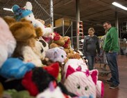 Parents stare at a table full of stuff animals before deciding on one during the base’s annual toy drive at Eglin Air Force Base, Fla., Dec. 2. Approximately 2,000 toys were collected by donations made throughout the year. Toys, bikes, books, games, crafts, sports equipment and stuffed animals were given to active-military families in need of assistance during the holidays. (U.S. Air Force photo/Samuel King Jr.)