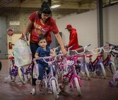 A mother checks to see if a bike is a good fit for her daughter during the base’s annual toy drive at Eglin Air Force Base, Fla., Dec. 2. Approximately 2,000 toys were collected by donations made throughout the year. Toys, bikes, books, games, crafts, sports equipment and stuffed animals were given to active-military families in need of assistance during the holidays. (U.S. Air Force photo/Samuel King Jr.)