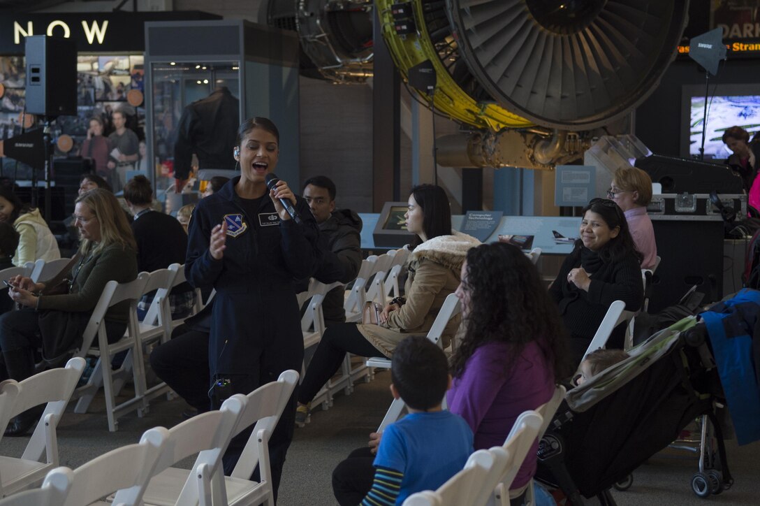 Tech. Sgt. Nalani Quintello, U.S. Air Force’s premier rock band, Max Impact, lead vocalist, sings to children at the Smithsonian National Air and Space Museum in Washington, D.C., Dec. 2, 2016. The band played a variety of holiday favorites for their audience and those passing by. (U.S. Air Force photo by Senior Airman Mariah Haddenham)