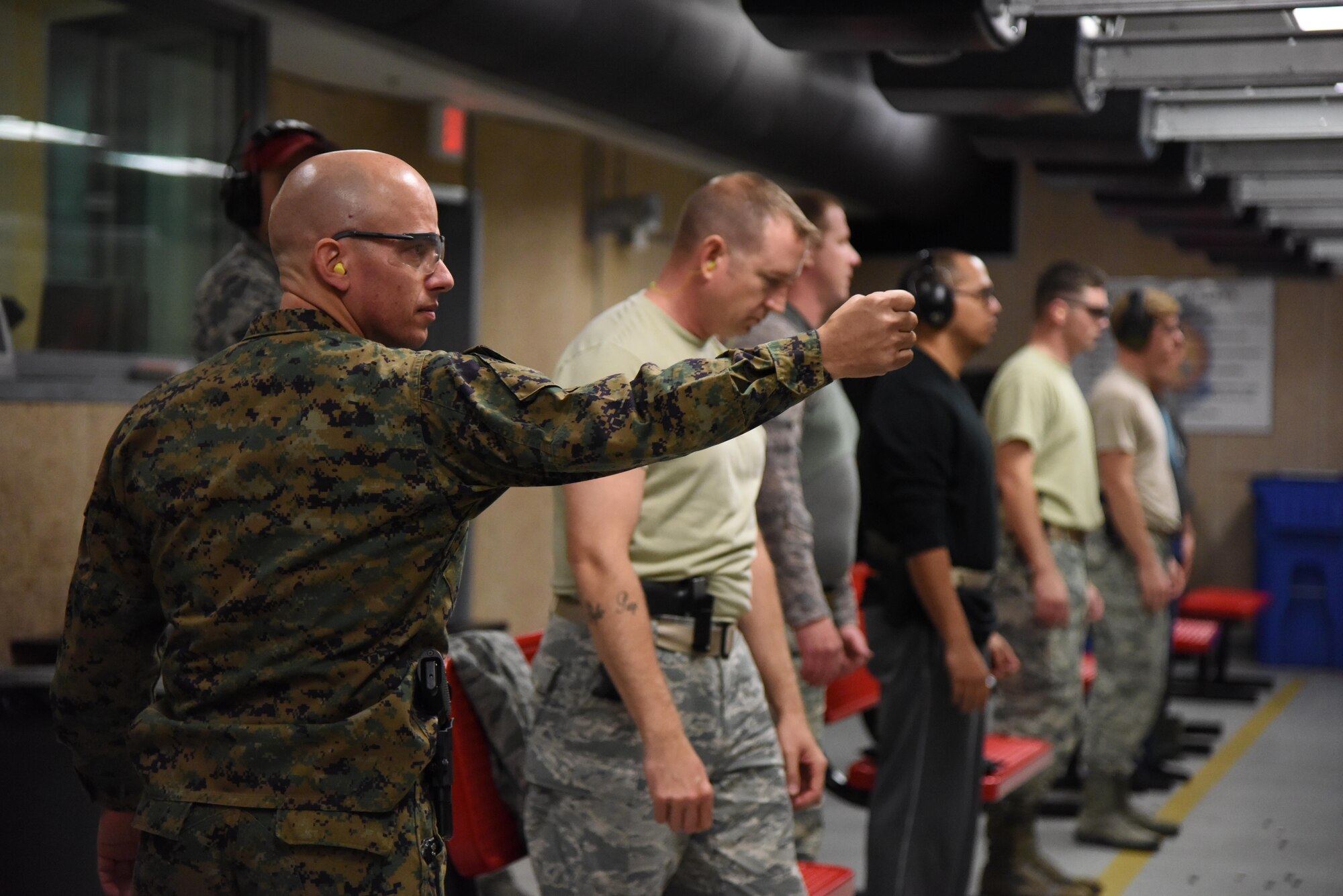 U.S. Marine Corps Gunnery Sgt. Michael Heacock, Keesler Marine Detachment instructor, readies himself before participating in the 81st Security Forces Squadron “Top Shot” competition Dec. 1, 2016, on Keesler Air Force Base, Miss. The event was held at the indoor firing range to raise funds for the Combined Federal Campaign. (U.S. Air Force photo by Kemberly Groue)