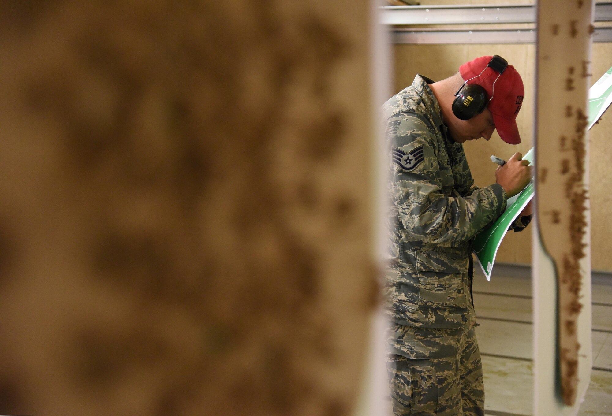 Staff Sgt. Matthew Keel, 81st Security Forces Squadron combat arms instructor, calculates scores on targets during the 81st Security Forces Squadron “Top Shot” competition Dec. 1, 2016, on Keesler Air Force Base, Miss. The event was held at the indoor firing range to raise funds for the Combined Federal Campaign. (U.S. Air Force photo by Kemberly Groue)
