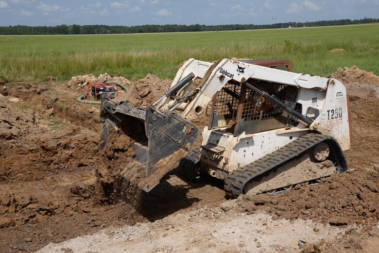 Senior Airman Nathaniel Henkel, 823rd Rapid Engineer Deployable Heavy Operational Repair Squadron, Engineering, Hurlburt Field, Florida, clears a lane of dirt on the flightline of Columbus Air Force Base, Mississippi, July 12. REDHORSE estimates the RSU project will be completed within two weeks. (U.S. Air Force photo/Airman 1st Class John Day)