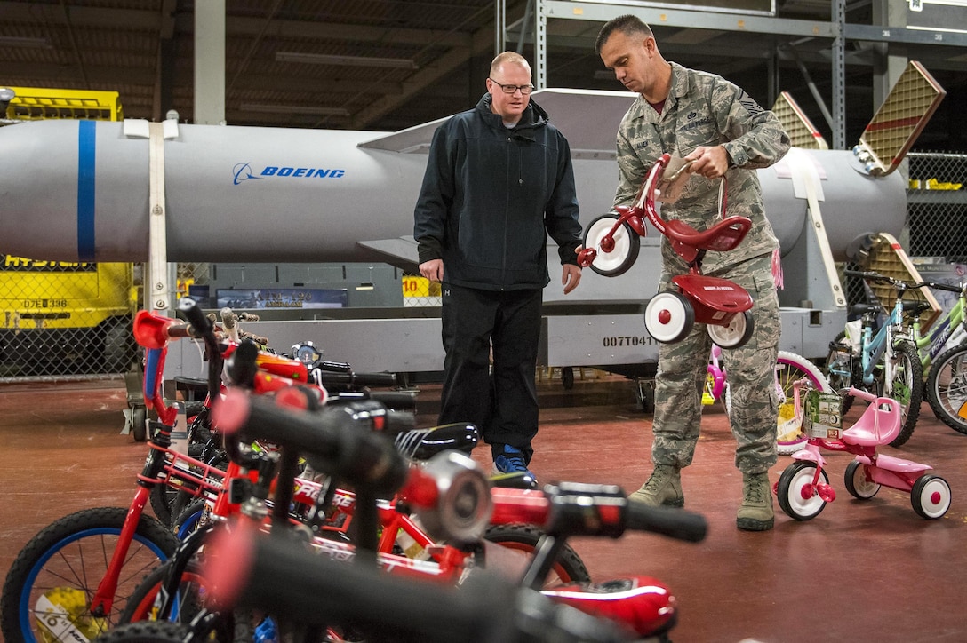 An Air Force first sergeant helps a parent choose a tricycle during the annual toy drive at Eglin Air Force Base, Fla., Dec. 2, 2016. The drive collected about 2,000 toys for military families in need of assistance during the holidays. Air Force photo/Samuel King Jr.