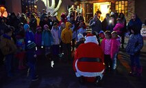 Santa delivers candy canes during a surprise visit with children outside Freedom Chapel at Ellsworth Air Force Base S.D., Dec. 1, 2016. After Santa’s arrival, the children were invited inside to create holiday themed-crafts. (U.S. Air Force photo by Airman 1st Class James L. Miller)
