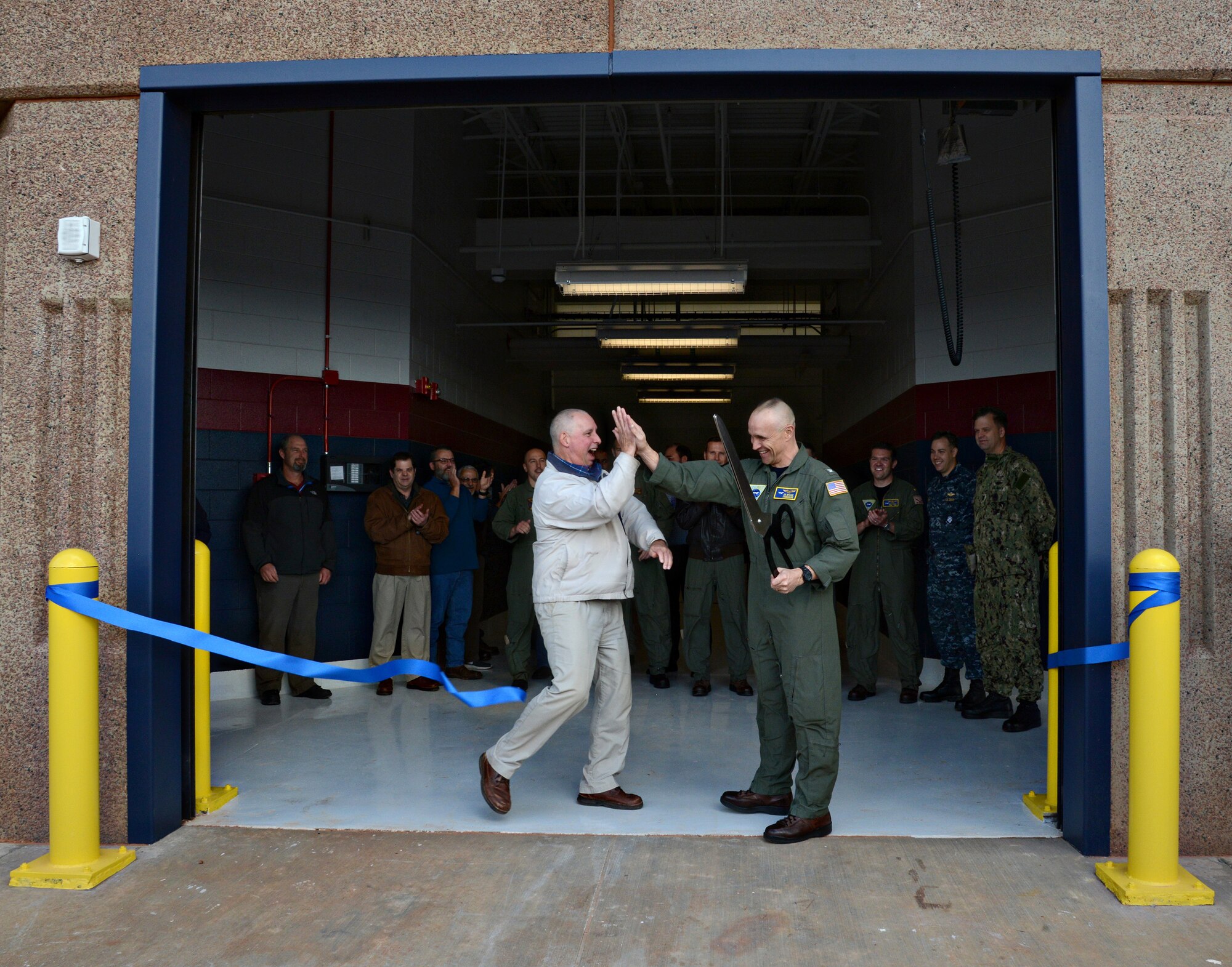 Scott Appleton, with HGL Construction in Midwest City, left, and Capt. Ed McCabe, commander of Strategic Communications Wing ONE and Task Force 124, cut the ceremonial ribbon Nov. 22, officially opening Bldg. 824, TACAMO’s newest hangar. The 36,000-square-foot building will be able to accommodate depot-level maintenance on the Navy’s E-6B Mercury. (Air Force photo by Kelly White)