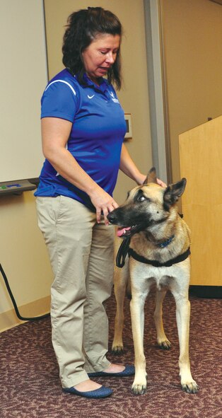 Retired Master Sgt. Lisa Hodgden speaks Nov. 23 at the Airman and Family Readiness Center about her combat injuries and ongoing recovery. The Moore resident said her participation in the Wounded Warrior Games, in shot put and discus, was key to overcoming depression and anger about her injuries, the loss of two Air Force comrades, and Post-Traumatic Stress Disorder. At her side is her service dog. (Air Force photo by Kimberly Woodruff)