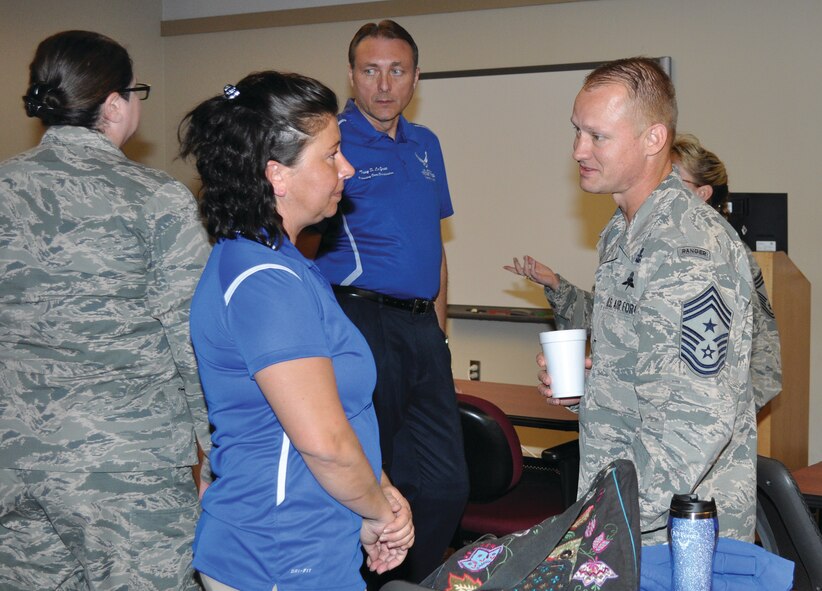 Retired Master Sgt. Lisa Hodgden talks to 552nd Air Control Wing Command Chief Master Sgt. Mark Hurst after an inspiring talk about her ordeals. Air Force Recovery Care Coordinator, Tony LaGree, stands in the background. (Air Force photo by Kimberly Woodruff)