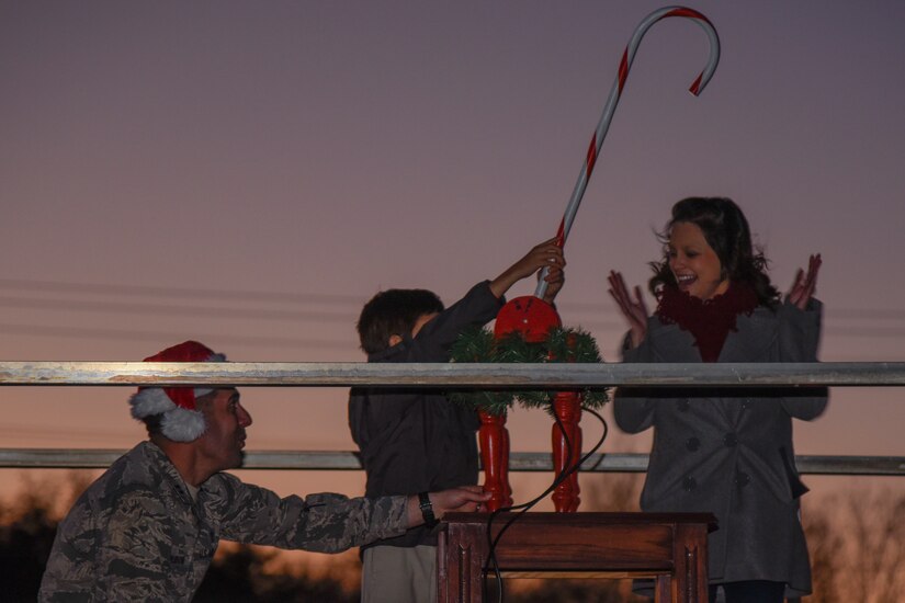 Jacob Nedrow, center, a deployed member’s child, flips the switch to light the base Christmas tree on Joint Base Andrews, Md., Dec. 1, 2016. Capt. Gregory Dubow, left, 11th Wing Chaplain and Theresa Nedrow, Jacob’s mother, stand beside Jacob as he turns the candy cane handle. The tree lighting provides the base with a time to celebrate holiday cheer and to take a moment to remember service members deployed during the holidays. (U.S. Air Force photo by Airman 1st Class Valentina Lopez)