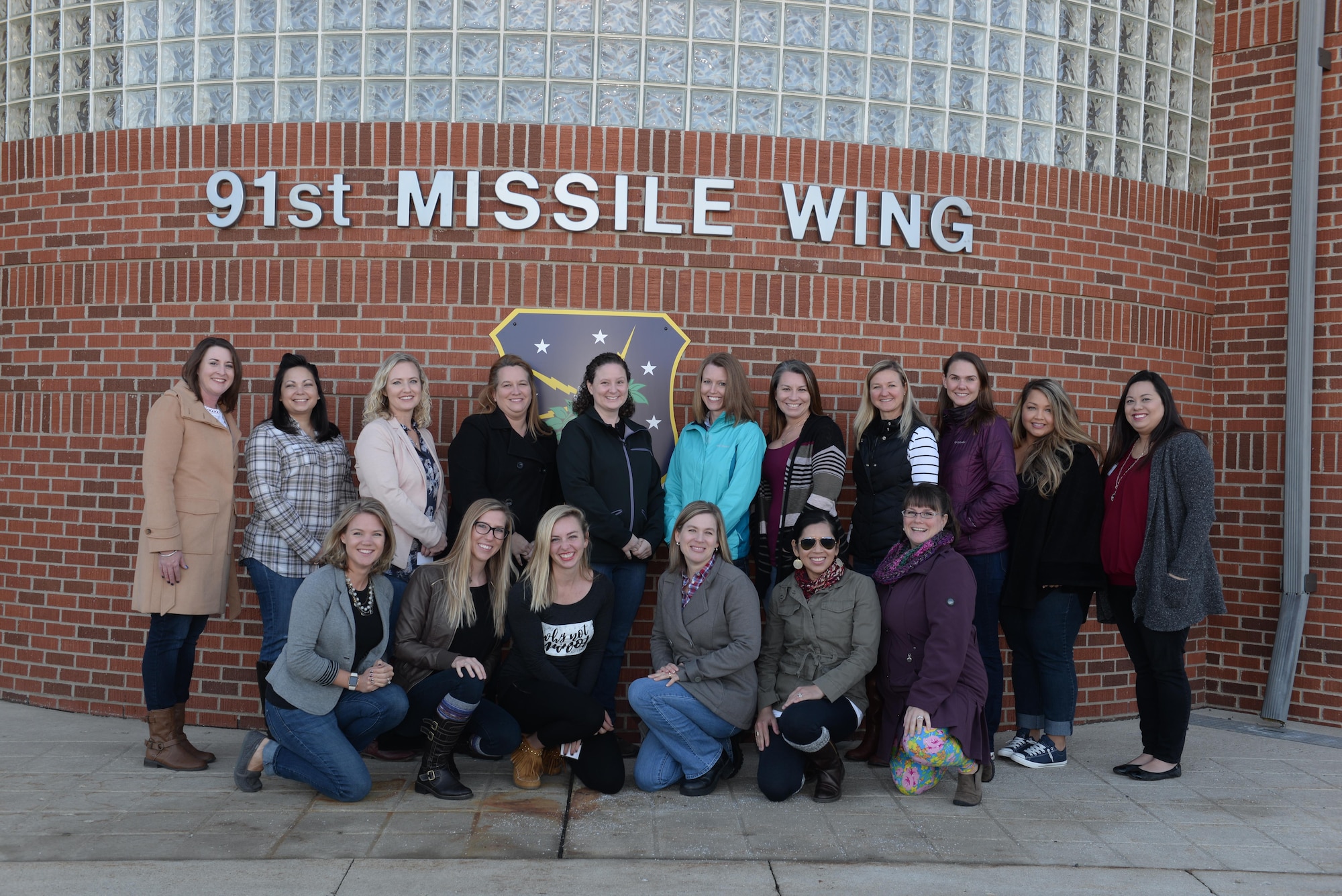 Spouses of 91st Missile Wing and 5th Bomb Wing senior-leadership pose for a group photo before a tour at Minot Air Force Base, N.D., Dec. 2, 2016. The spouses toured missile alert facilities, a trainer launch facility and various support operations facilities. (U.S. Air Force photo/Airman 1st Class Jessica Weissman)