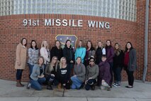 Spouses of 91st Missile Wing and 5th Bomb Wing senior-leadership pose for a group photo before a tour at Minot Air Force Base, N.D., Dec. 2, 2016. The spouses toured missile alert facilities, a trainer launch facility and various support operations facilities. (U.S. Air Force photo/Airman 1st Class Jessica Weissman)