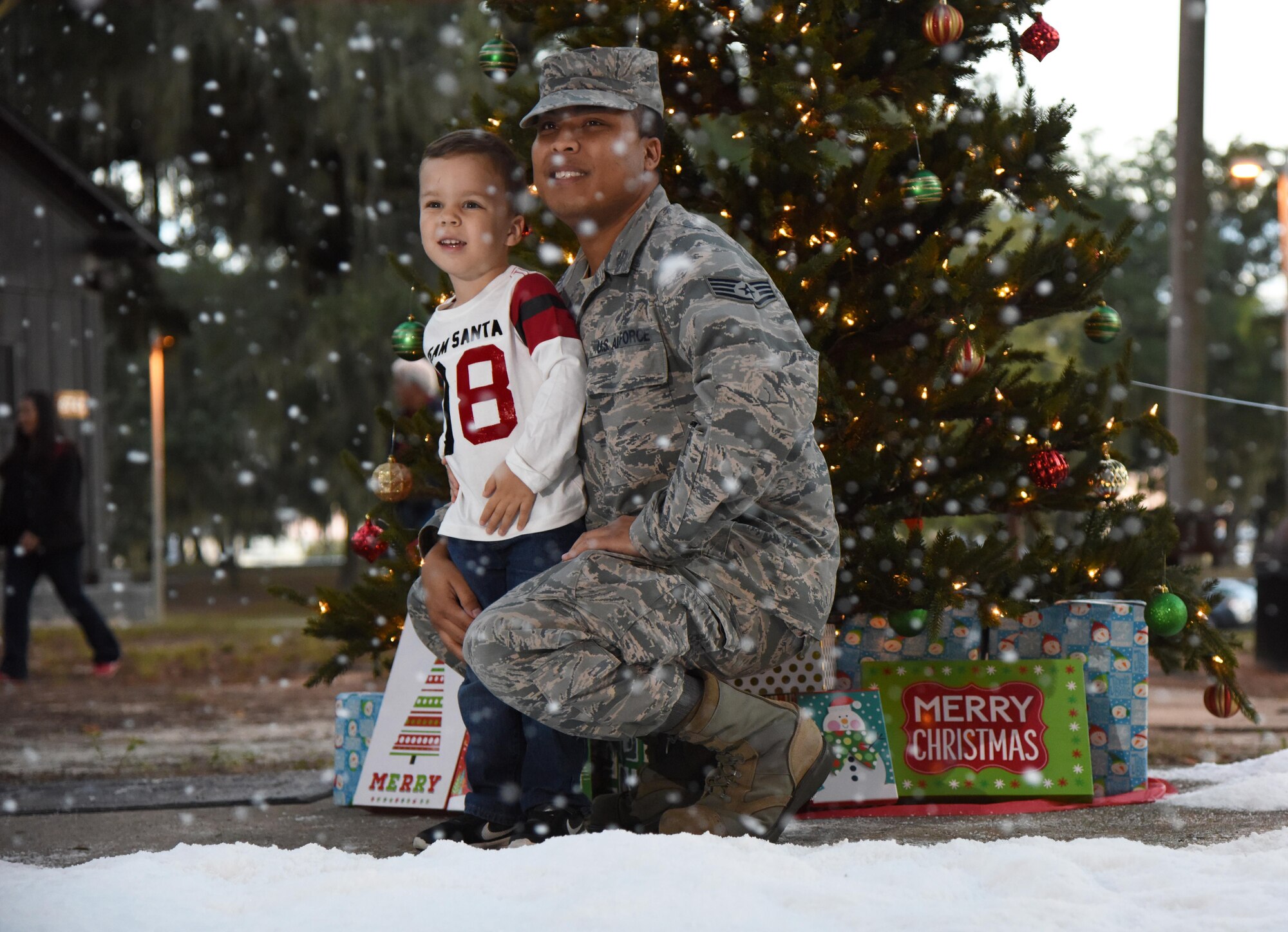 Staff Sgt. Donald Mickens, 81st Medical Support Squadron information systems NCO in charge, and his son, Tristan, pose for a photo during Keesler’s annual Christmas in the Park celebration at Marina Park Dec. 1, 2016, on Keesler Air Force Base, Miss. The event, hosted by Outdoor Recreation, included a tree lighting ceremony, marina tour train rides, cookie and ornament decorating, and visits with Santa. (U.S. Air Force photo by Kemberly Groue)