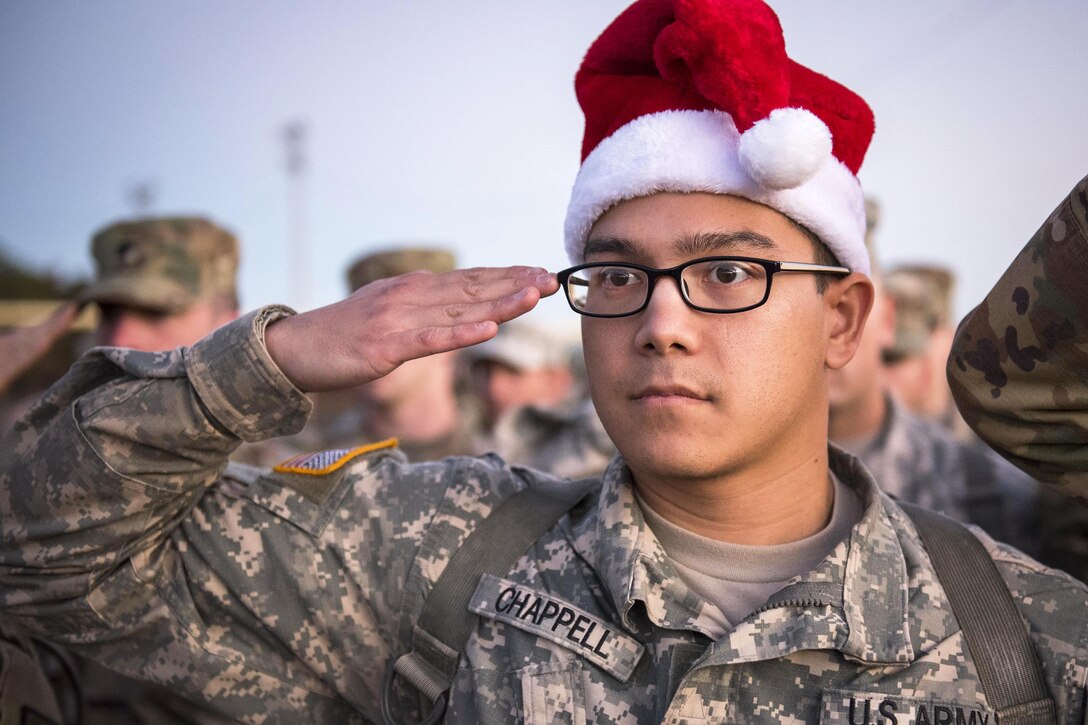 A soldier helping with a toy drive at Eglin Air Force Base, Fla., salutes during a base retreat ceremony, Dec. 1, 2016. Air Force photo by Samuel King Jr.