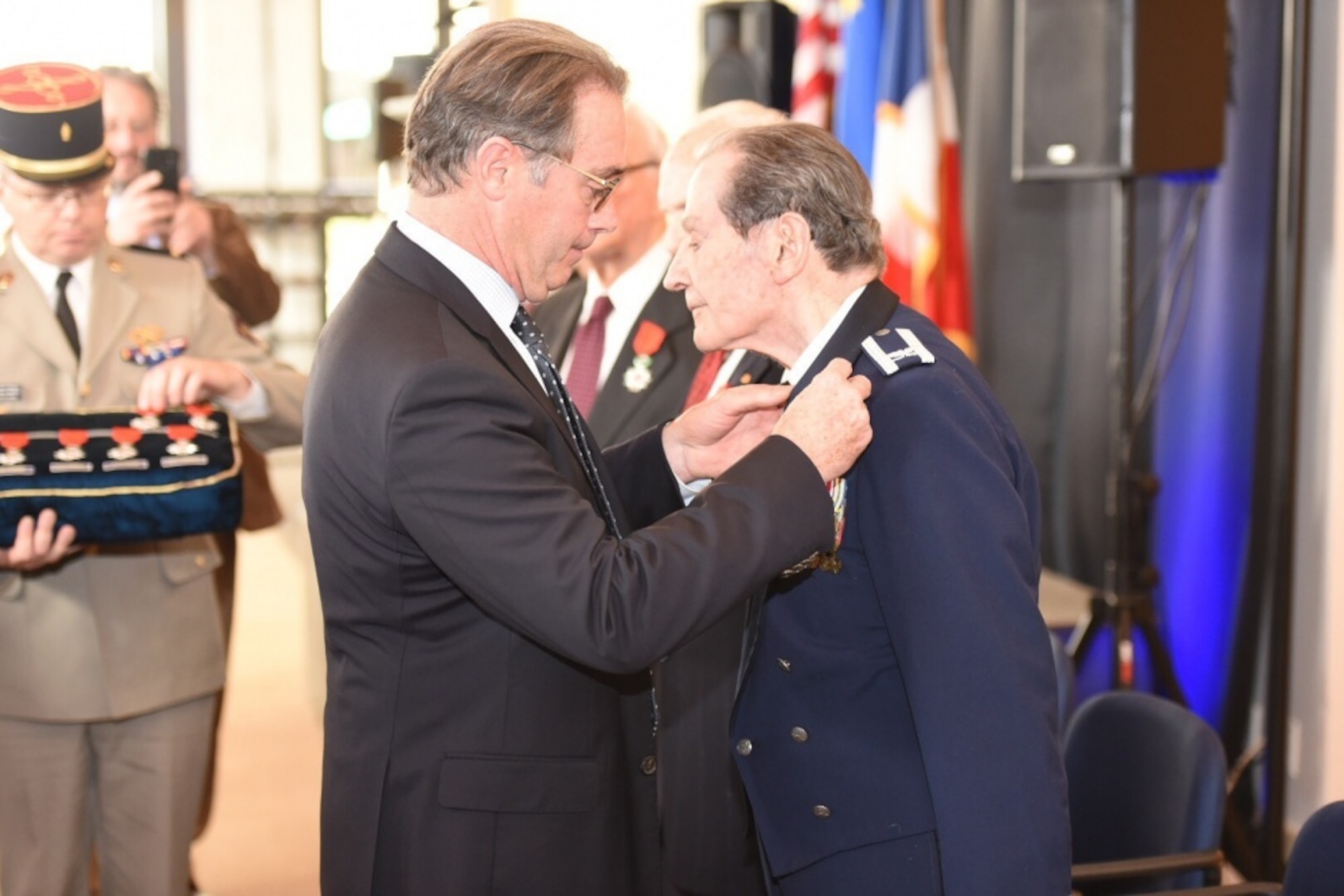 French Consul General, Michael Charbonnier, pins the Chevalier of the Legion of Honor medal to Air Force Col. (ret) Arnold Gabriel during a ceremony at the French Embassy in Washington, D.C., Nov 10, to honor other World War II veterans who helped in the liberation of France. Gabriel who retired from the Air Force as a conductor for the band was an Army machine gunner. (Navy photo by Eric Ritter)