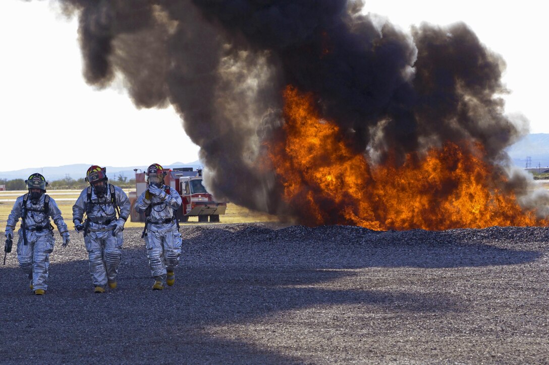 Air Force firefighters walk away from a fire during training on the fire training grounds at Davis-Monthan Air Force Base, Ariz., Nov. 28, 2016. The firefighters are assigned to the 355th Civil Engineer Squadron’s fire department. Air Force photo by Senior Airman Betty R. Chevalier