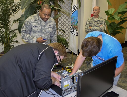 Members of the 919th Special Operations Communications Squadron watch and keep time while kids put together a desktop computer at this year’s Tech Bowl in Niceville Fla., Nov. 5.  The reservists acted as timekeepers and judges for the youth competition.  (Courtesy photo)