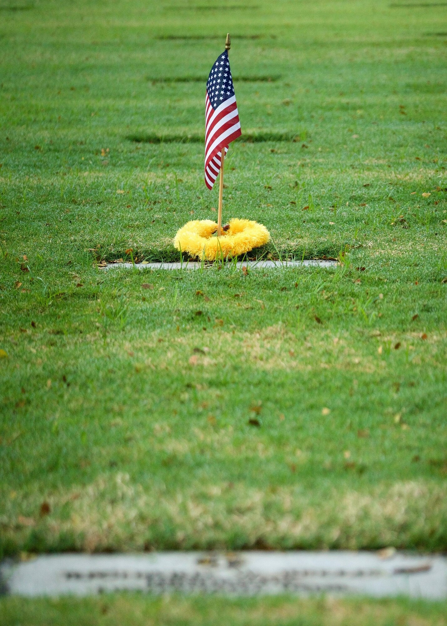 A commemorative U.S. flag rests next to a gravemarker at the National Memorial Cemetery of the Pacific, Honolulu, Hawaii, Dec. 3, 2016. The flag was placed by U.S. Airmen during a commemoration ceremony honoring the courage, service and sacrifice of the U.S. military personnel who died during the attacks on Pearl Harbor and Oahu on Dec. 7, 1941. Dec. 7, 2016 marks the 75th anniversary of the attacks and the U.S. military and the State of Hawaii are hosting a series of remembrance events to honor the Pacific Theater's veterans. (U.S. Air Force photo by Tech. Sgt. James Stewart/Released)