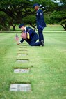 U.S. Air Force Staff Sgt. Johnnie Anderson and Airman 1st Class Andrew Titus, dental technicians with the 15th Aeromedical Squadron, place a commemorative U.S. flag near a gravemarker at the National Memorial Cemetery of the Pacific, Honolulu, Hawaii, Dec. 3, 2016. Anderson and Titus placed multiple flags during a commemoration ceremony honoring the courage, service and sacrifice of the U.S. military personnel who died during the attacks on Pearl Harbor and Oahu on Dec. 7, 1941. Dec. 7, 2016 marks the 75th anniversary of the attacks and the U.S. military and the State of Hawaii are hosting a series of remembrance events to honor the Pacific Theater's veterans. (U.S. Air Force photo by Tech. Sgt. James Stewart/Released)
