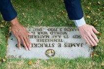 U.S. Air Force Staff Sgt. Johnnie Anderson and Airman 1st Class Andrew Titus, dental technicians with the 15th Aeromedical Squadron, clear fallen leaves from U.S. Army Air Forces Sgt. James Strickland's  gravemarker at the National Memorial Cemetery of the Pacific, Honolulu, Hawaii, Dec. 3, 2016. After clearing the gravemarker, Anderson and Titus placed a commemorative flag to honor Strickland's courage, service and sacrifice during the attacks on Pearl Harbor and Oahu on Dec. 7, 1941. Dec. 7, 2016 marks the 75th anniversary of the attacks and the U.S. military and the State of Hawaii are hosting a series of remembrance events to honor the Pacific Theater's veterans. (U.S. Air Force photo by Tech. Sgt. James Stewart/Released)