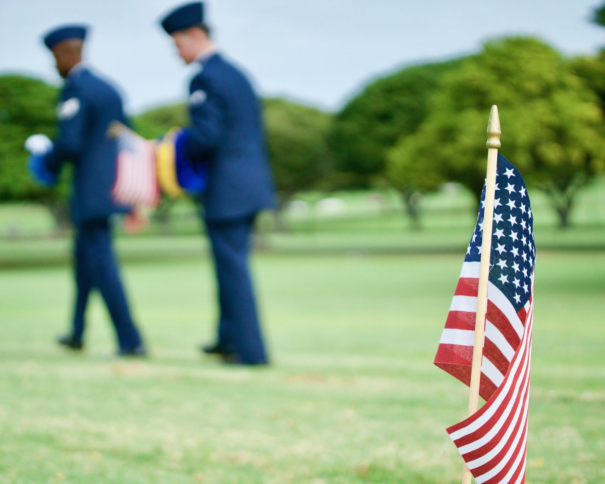U.S. Air Force Staff Sgt. Johnnie Anderson and Airman 1st Class Andrew Titus, dental technicians with the 15th Aeromedical Squadron, walk among gravemarkers after having placed a commerative U.S. flag at the National Memorial Cemetery of the Pacific, Honolulu, Hawaii, Dec. 3, 2016. Anderson and Titus placed multiple flags during a commemoration ceremony honoring the courage, service and sacrifice of the U.S. military personnel who died during the attacks on Pearl Harbor and Oahu on Dec. 7, 1941. Dec. 7, 2016 marks the 75th anniversary of the attacks and the U.S. military and the State of Hawaii are hosting a series of remembrance events to honor the Pacific Theater's veterans. (U.S. Air Force photo by Tech. Sgt. James Stewart/Released)