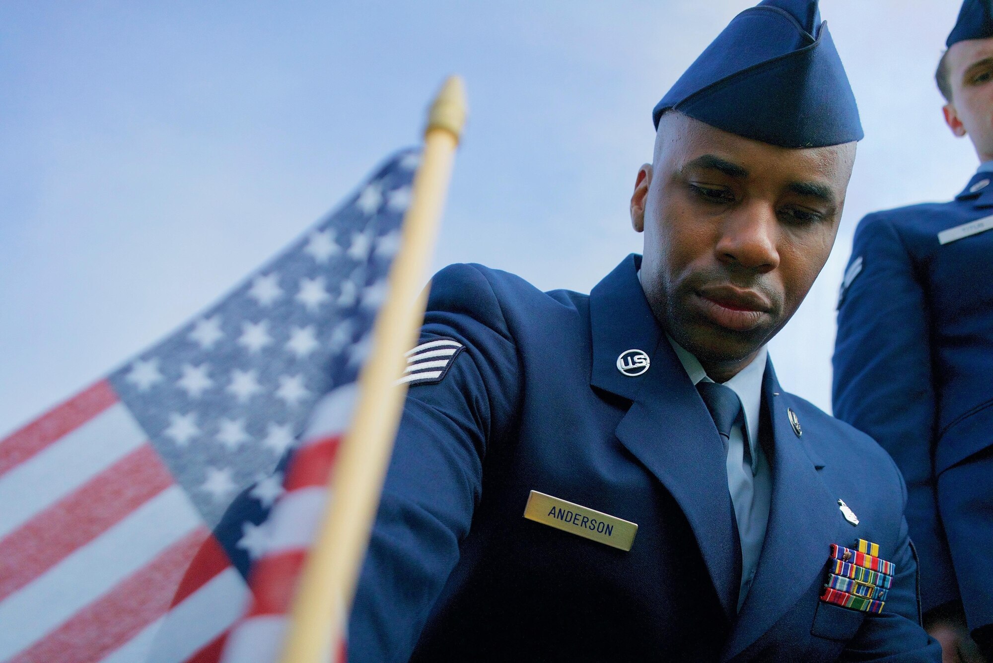U.S. Air Force Staff Sgt. Johnnie Anderson, a dental technician with the 15th Aeromedical Squadron, places a commemorative U.S. flag near a gravemarker at the National Memorial Cemetery of the Pacific, Honolulu, Hawaii, Dec. 3, 2016. Anderson placed multiple flags during a commemoration ceremony honoring the courage, service and sacrifice of the U.S. military personnel who died during the attacks on Pearl Harbor and Oahu on Dec. 7, 1941. Dec. 7, 2016 marks the 75th anniversary of the attacks and the U.S. military and the State of Hawaii are hosting a series of remembrance events to honor the Pacific Theater's veterans. (U.S. Air Force photo by Tech. Sgt. James Stewart/Released)
