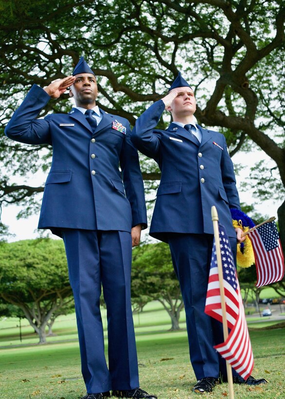 U.S. Air Force Staff Sgt. Johnnie Anderson and Airman 1st Class Andrew Titus, dental technicians with the 15th Aeromedical Squadron, salute a fallen U.S. servicemember's  gravemarker at the National Memorial Cemetery of the Pacific, Honolulu, Hawaii, Dec. 3, 2016. Anderson and Titus placed multiple flags during a commemoration ceremony honoring the courage, service and sacrifice of the U.S. military personnel who died during the attacks on Pearl Harbor and Oahu on Dec. 7, 1941. Dec. 7, 2016 marks the 75th anniversary of the attacks and the U.S. military and the State of Hawaii are hosting a series of remembrance events to honor the Pacific Theater's veterans. (U.S. Air Force photo by Tech. Sgt. James Stewart/Released)