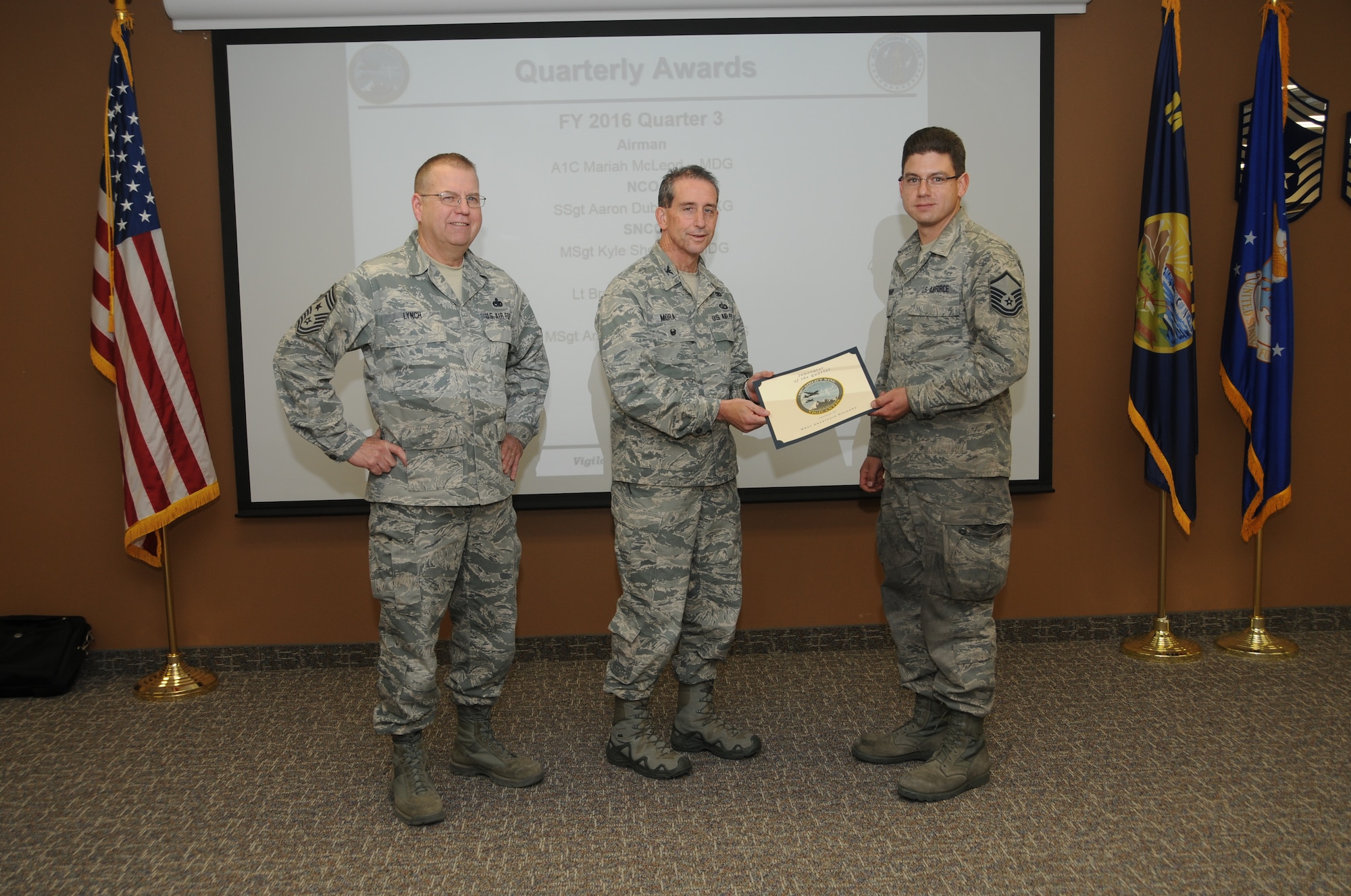 120th Airlift Wing Vice Commander Col. Thomas Mora and 120th AW Command Chief Master Sgt. Steven Lynch presented the Fiscal Year 2016 3rd quarter award winners for the 120th Airlift Wing of the Montana Air National Guard during the Stand-up Briefing held in the Larsen Room of the wing headquarters building Nov. 4, 2016. Master Sgt. Anastacio Navarro, an airlift aircraft maintenance craftsman assigned to the 120th Maintenance Group, was awarded the Innovator of the Quarter Award.