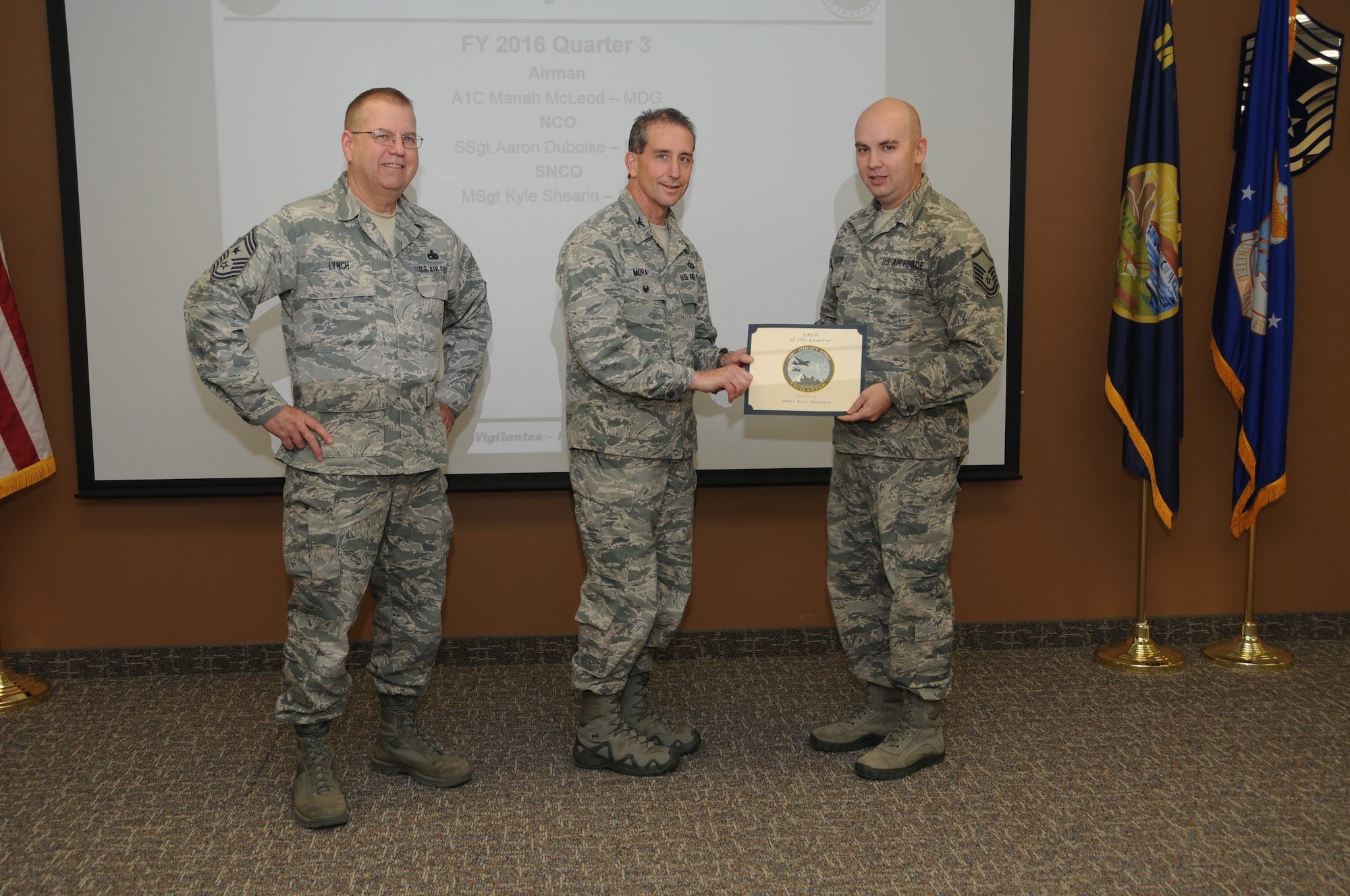 120th Airlift Wing Vice Commander Col. Thomas Mora and 120th AW Command Chief Master Sgt. Steven Lynch presented the Fiscal Year 2016 3rd quarter award winners for the 120th Airlift Wing of the Montana Air National Guard during the Stand-up Briefing held in the Larsen Room of the wing headquarters building Nov. 4, 2016. Public Health Craftsman Sgt. Kyle Shearin from the 120th Medical Group won in the senior noncommissioned officer category.