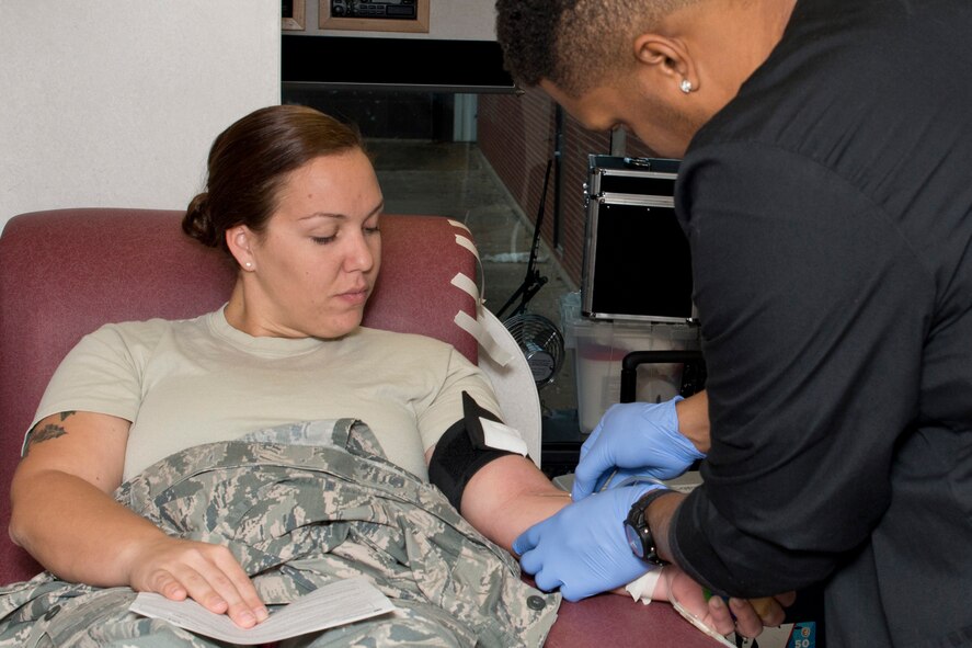 U.S. Air Force Reserve Staff Sgt. Jillian McCambridge, air transportation, 96th Aerial Port Squadron, looks on as Clifton Cogshell, a phlebotomist for the Arkansas Blood Institute (ABI), prepares to draw blood, Dec. 3, 2016, at Little Rock Air Force Base, Ark.  Airmen from the 913 AG did their part to support the community, and in turn their own families, by donating more than 26 units of blood to the Arkansas Blood Institute. (U.S. Air Force photo by Master Sgt. Jeff Walston/Released)