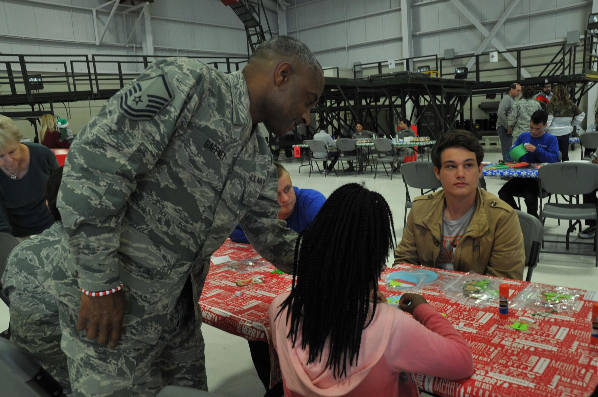 Master Sgt. David Gaffney, 403rd Wing recruiter from the Mobile office, watches and helps his daughter at the ornament table.  Members of the 403rd Wing and their families visit with Santa during the 403rd Wing children's holiday party Dec. 3, 2016.  (U.S. Air Force photo/Master Sgt. Jessica Kendziorek)