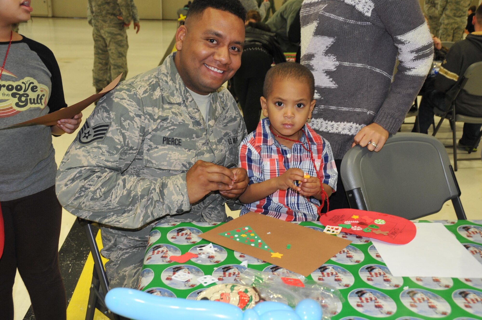 Staff Sgt. William Pierce, 403rd Maintenace Squadron fuel cell specialist, and his son Mason work together to create a Christmas card.  Members of the 403rd Wing and their families visit with Santa during the 403rd Wing children's holiday party Dec. 3, 2016.  (U.S. Air Force photo/Master Sgt. Jessica Kendziorek)