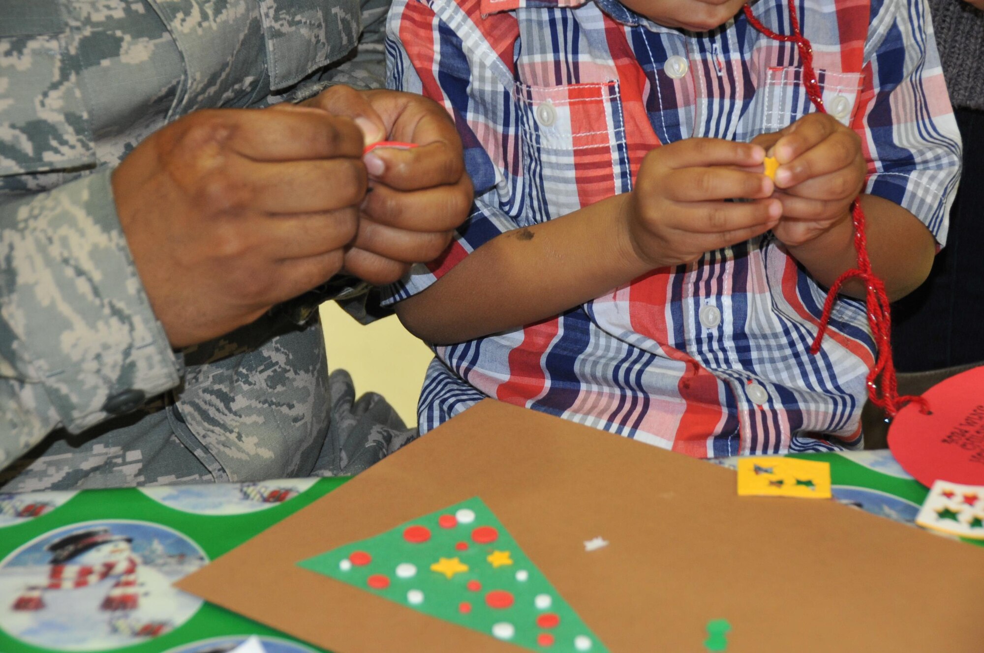 Staff Sgt. William Pierce, 403rd Maintenace Squadron fuel cell specialist, and his son Mason work together to create a Christmas card.  Members of the 403rd Wing and their families visit with Santa during the 403rd Wing children's holiday party Dec. 3, 2016.  (U.S. Air Force photo/Master Sgt. Jessica Kendziorek)