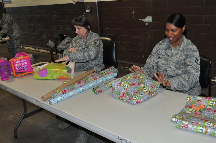 (Left) Senior Master Sgt. Laura Trent, 433rd Maintenance Group plans and scheduling supervisor, and Staff Sgt. Winnett Knox, 433rd Force Support Squadron family readiness specialist, wrap gifts for the 433rd Airlift Wing’s Angel Tree at Joint Base San Antonio-Lackland, Texas Dec. 3, 2016. The program supports the Salvation Army San Antonio who gives the gifts to families in need throughout the local community. (U.S. Air Force photo/Senior Airman Bryan Swink)