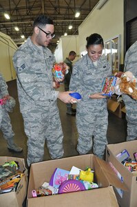 (Left) Senior Airman Eddie Castillo and Airman Ashley Garcia, both 433rd Force Support Squadron services technicians, find the perfect gifts to fill stockings during a free stocking stuffer giveaway at Joint Base San Antonio-Lackland, Texas Dec. 3, 2016.  The gifts were donated by Operation Homefront, who donate millions of toys each year to military families during the holiday season. (U.S. Air Force photo/Senior Airman Bryan Swink)