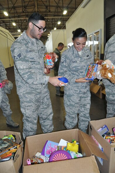 (Left) Senior Airman Eddie Castillo and Airman Ashley Garcia, both 433rd Force Support Squadron services technicians, find the perfect gifts to fill stockings during a free stocking stuffer giveaway at Joint Base San Antonio-Lackland, Texas Dec. 3, 2016.  The gifts were donated by Operation Homefront, who donate millions of toys each year to military families during the holiday season. (U.S. Air Force photo/Senior Airman Bryan Swink)