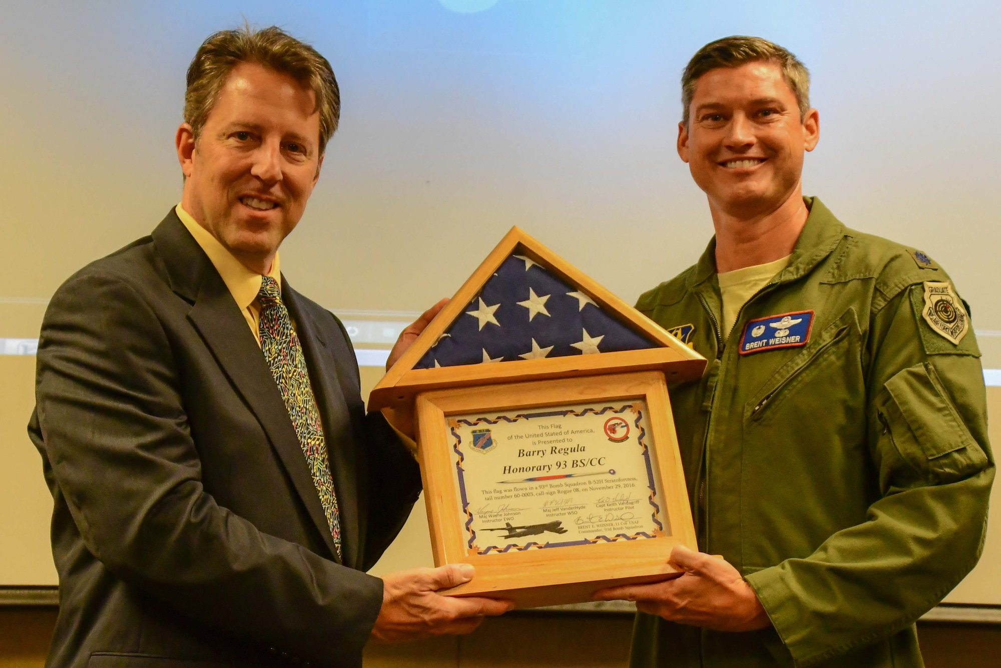 Margaritaville Resort Casino Vice President and General Manager Barry Regula receives a flag that was flown in the B-52 Stratofortress in his honor from U.S. Air Force Lt. Col. Brent Weisner, 93rd Bomb Squadron Commander, during a honorary commander’s induction ceremony at Barksdale Air Force Base, La. , December 2, 2016.  Regula is the first local civic leader to be appointed as an honorary commander at Barksdale. The Honorary Commanders’ Program was created to strengthen community relations throughout the Shreveport/Bossier City area and increase public awareness and understanding of the Air Force Reserve. (U.S. Air Force photo by Master Sgt. Laura Siebert)