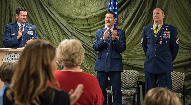 JOINT BASE ELMENDORF-RICHARDSON, Alaska -- Attendees applaud for Chief Master Sgt. Paul Bear Barendregt, a pararescueman and chief enlisted manager for the Alaska Air National Guard's 212th Rescue Squadron, at the conclusion of his retirement ceremony at the 212th's headquarters building here Dec. 3, 2016. Through his skill and commitment Barendregt exemplified the motto of the Air Force Pararescueman: These things we do, that others may live. (U.S. Air National Guard photo by Staff Sgt. Eagerton/released)