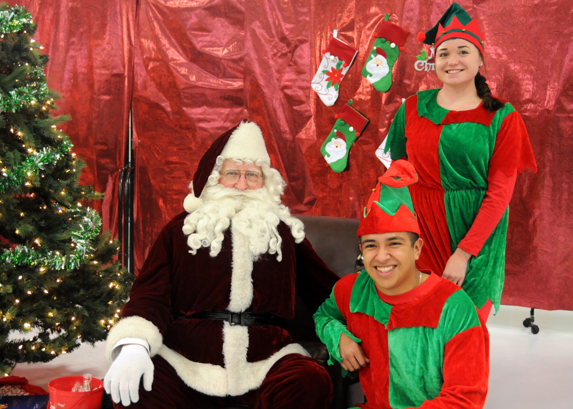 Victoria Fillipi, a member of the Iowa Guard Youth Council and Staff Sgt. Damian Huizar, a services Airmen assigned to the 185th Air Refueling Wing, pose for a photo with Santa at Sioux City Iowa, Dec. 3, 2016. Children got the opportunity to take their photo with Santa and play games as a part of Operation Santa’s Sleigh. (Iowa Air National Guard photo by Staff Sgt. Ter Haar/Released) 