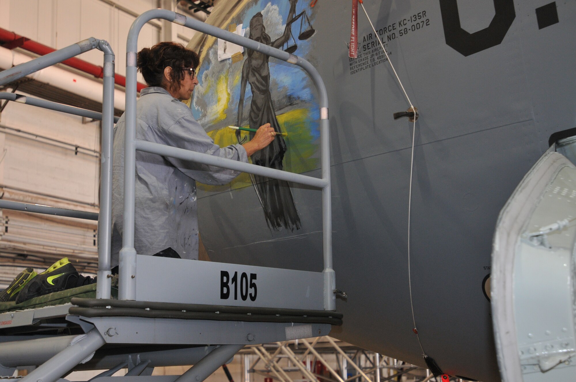 Donna Mrdjenovich paints nose art on a KC-135 aircraft near Pittsburgh Pennsylvania July 29, 2016 (U.S. Air National Guard Photo by Tech. Sgt. Michael Fariss)